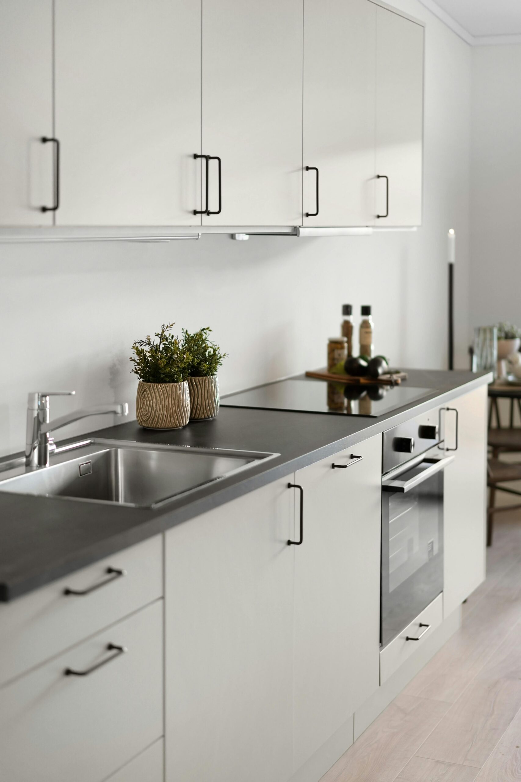 Sleek contemporary kitchen design featuring white cabinets and stainless steel appliances.